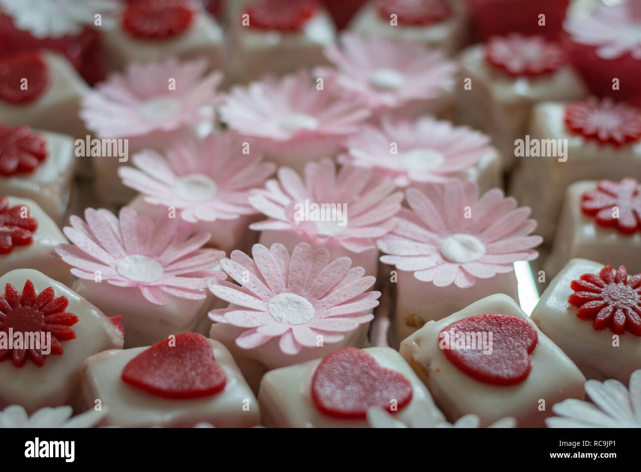 Colorato petit fours con decorazioni di fiori Foto Stock