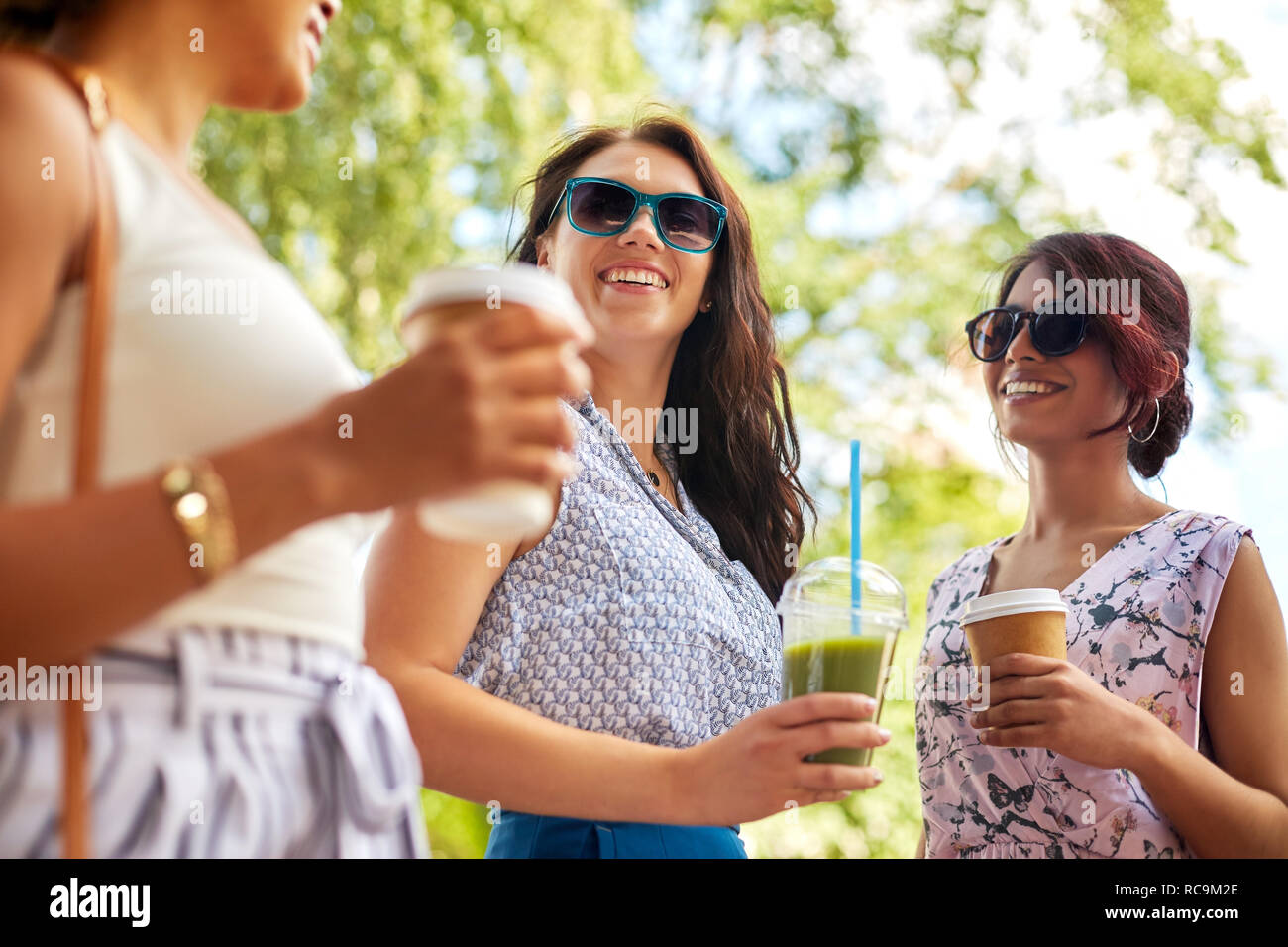 Felici donne o amici con bevande al summer park Foto Stock