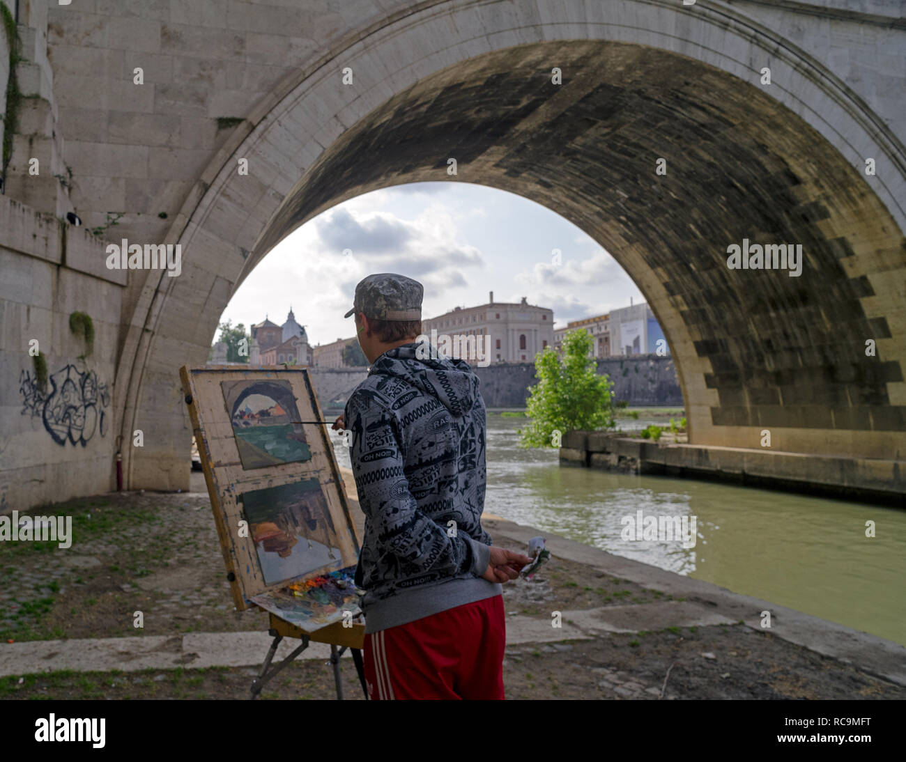 Roma, Italia, 05/06/2018: un artista dipinge un quadro sul quay al di sotto del ' sant'angelo bridge' lungo le rive del fiume Tevere. Foto Stock