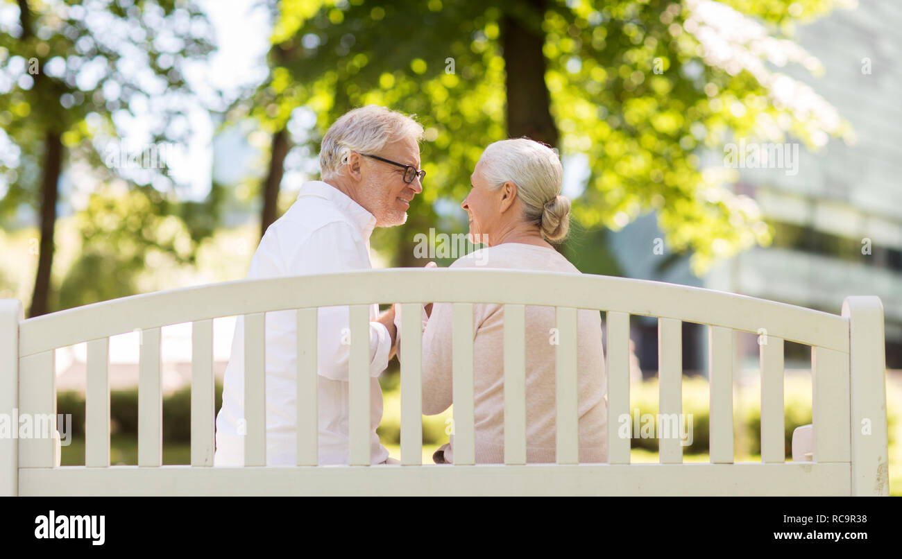 Felice coppia senior seduto su una panchina nel parco Foto Stock