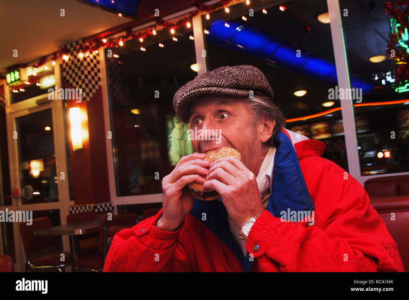 Mann mittleren altera isst Hamburger | middleaged uomo mangia hamburger Foto Stock