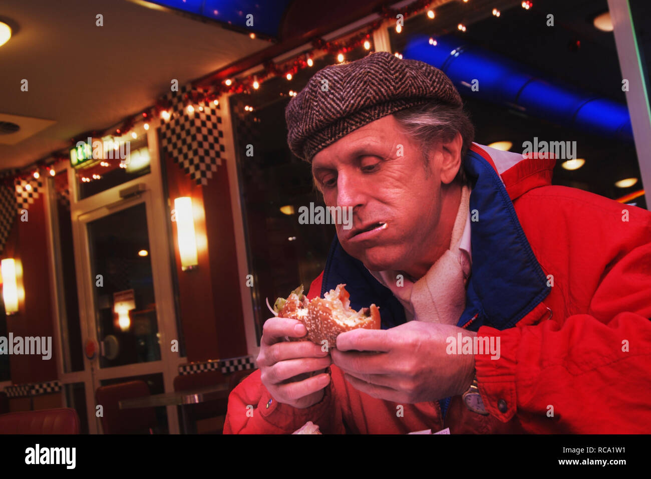 Mann mittleren altera isst Hamburger | middleaged uomo mangia hamburger Foto Stock