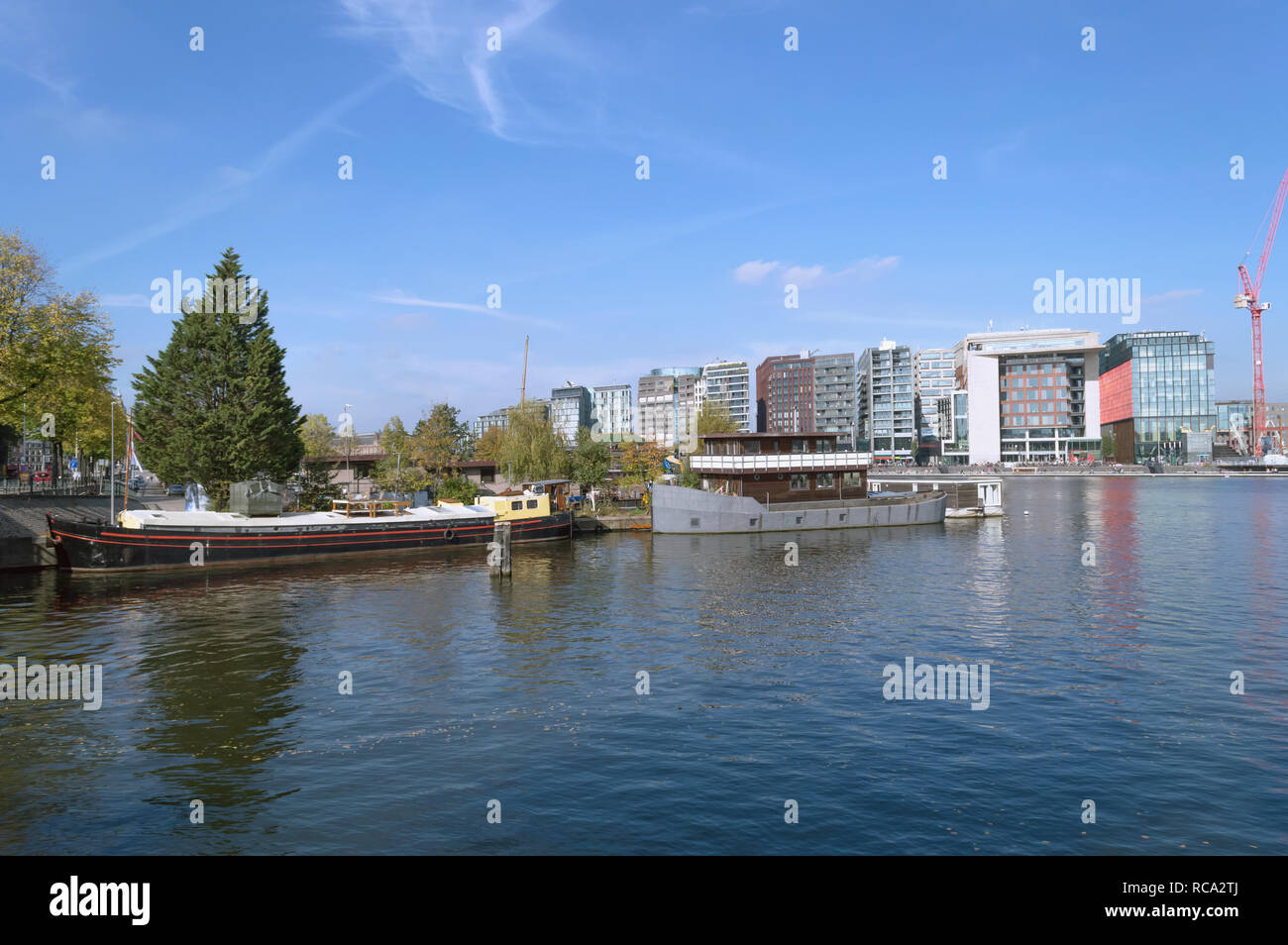 Paesaggio urbano moderno di Amsterdam con barche sulla soleggiata giornata di ottobre Foto Stock