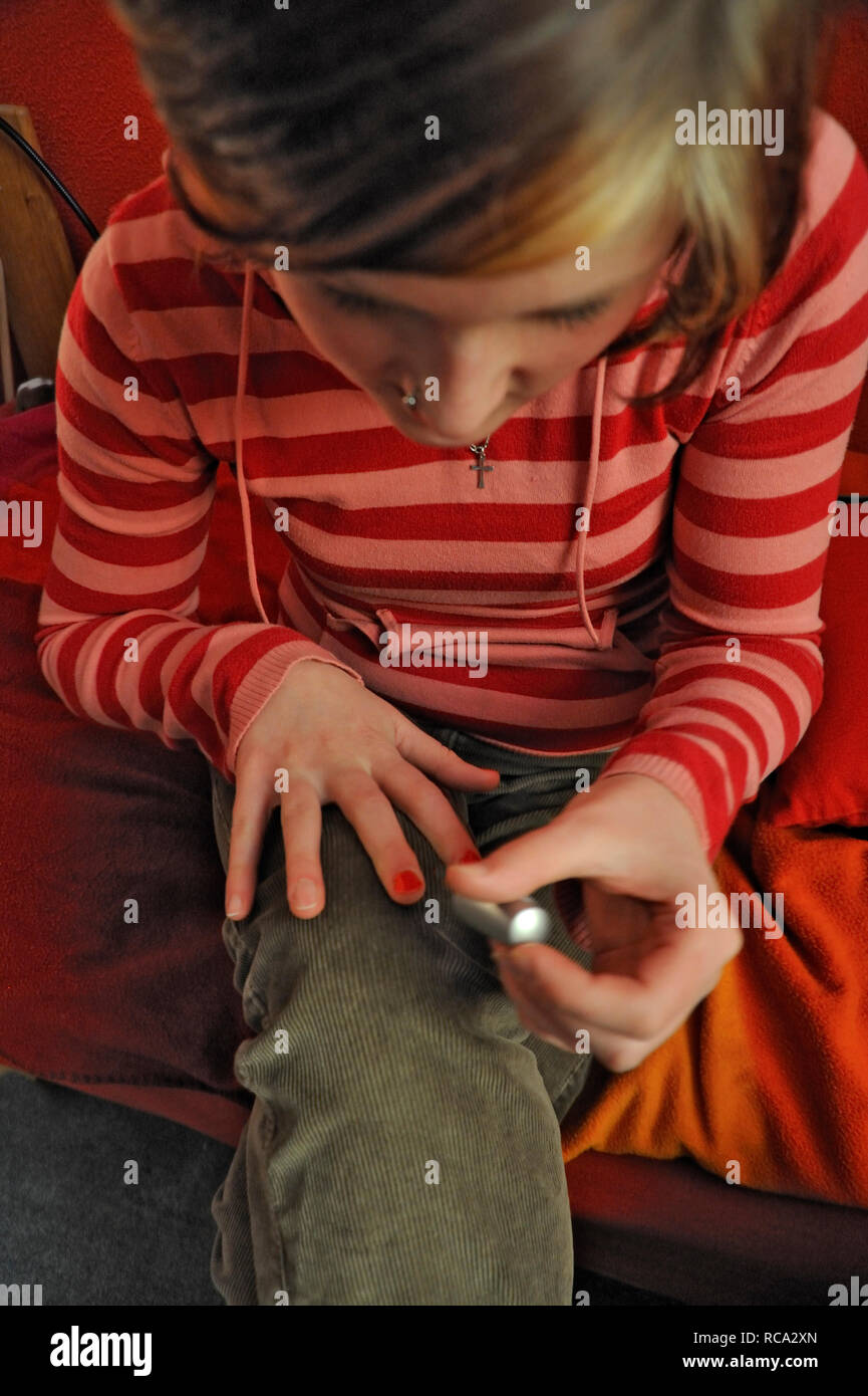 Junge Frau lackiert sich die Nägel | giovane donna verniciatura di lei le unghie Foto Stock