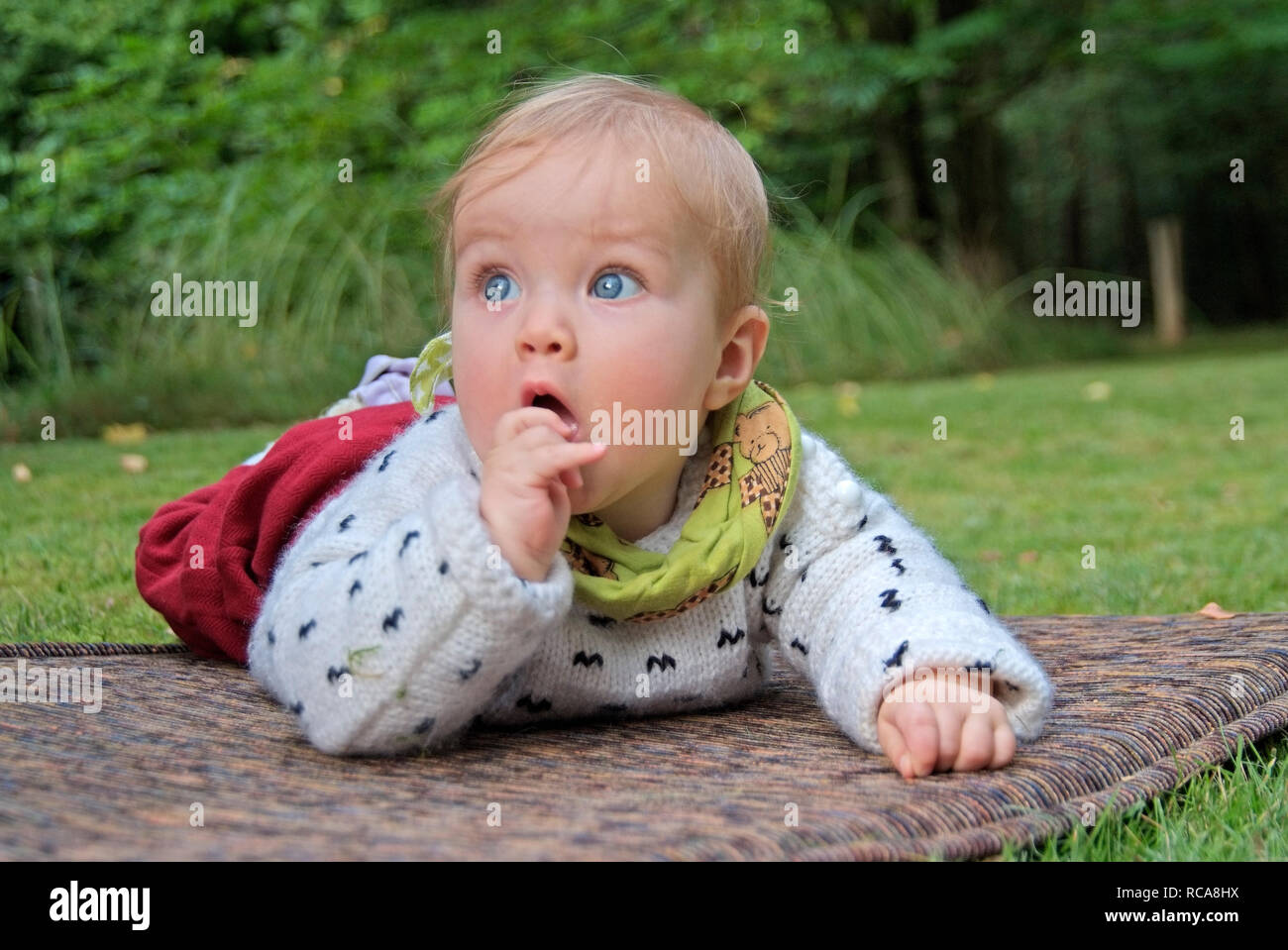 Baby liegt draußen auf einer Matte | baby giacente al di fuori su di un materasso Foto Stock