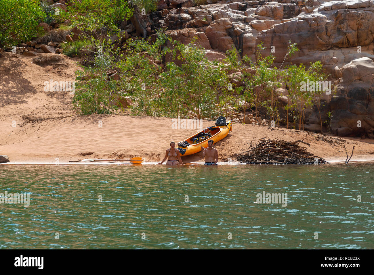 Coppia giovane con kayak seduto sulla spiaggia sabbiosa di Katherine Gorge, Nitmiluk National Park, Katherine, Territorio del Nord, l'estremità superiore, Australia Foto Stock