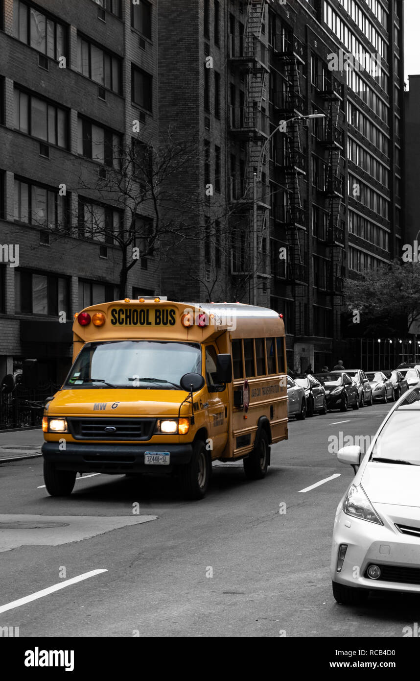 La città di New York, Stati Uniti - 17 Novembre 2018: un colore scegli la foto di una scuola di New York autobus a esso trascina verso West 56th Street Foto Stock