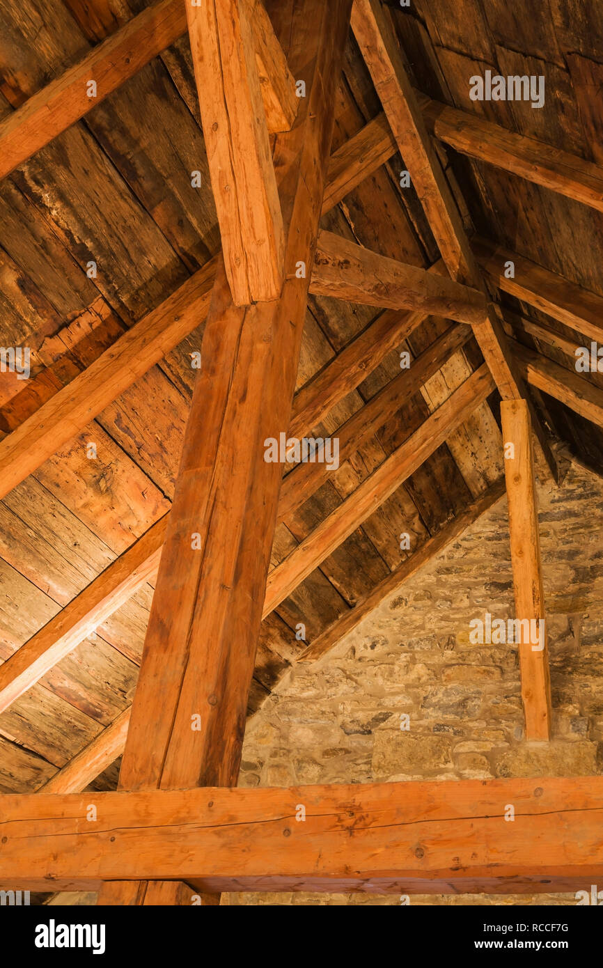 Travi in legno e pannelli di tetto a mansarda all'interno di un vecchio 1752 Canadiana fieldstone house Foto Stock