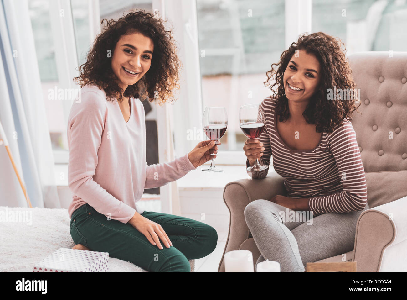 Belle Ragazze bere il vino che celebra l'amicizia anniversario Foto Stock