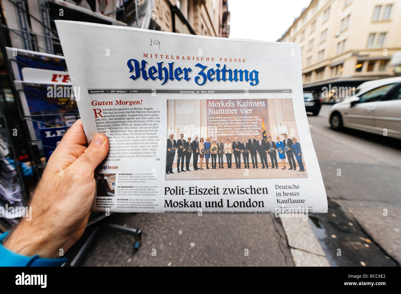 Parigi, Francia - Mar 15, 2017: uomo lettura tedesco acquisto Kehler Zeitung quotidiano a premere chiosco composto da Angela Dorothea Merkel ri elezione come cancelliere della Germania team Foto Stock