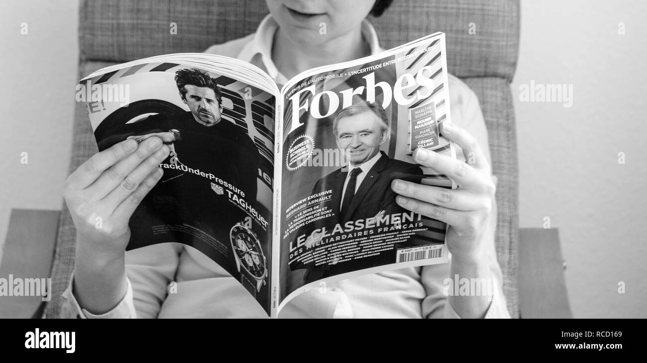 Parigi, Francia - Mar 16, 2018: immagine in bianco e nero di giovani business donna lettura del mondo elenco miliardari in Forbes Magazine con il CEO di LVMH Bernard Arnault sul coperchio Foto Stock