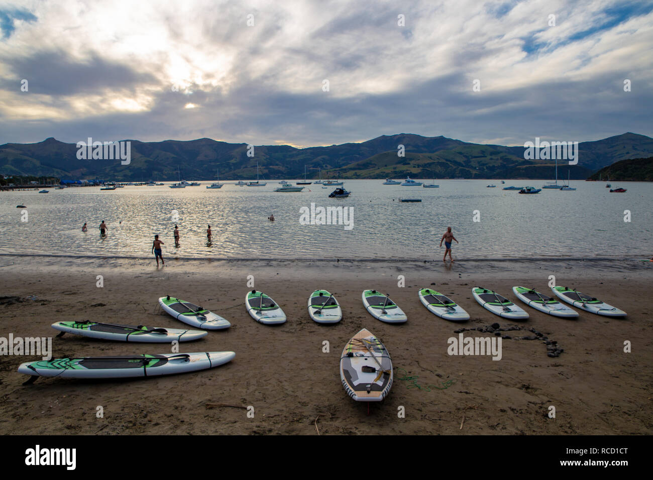 Akaroa, Canterbury, Nuova Zelanda - 5 Gennaio 2019: paddleboards sulla spiaggia di Akaroa pronto per essere assunto da turisti in una calda serata estiva Foto Stock