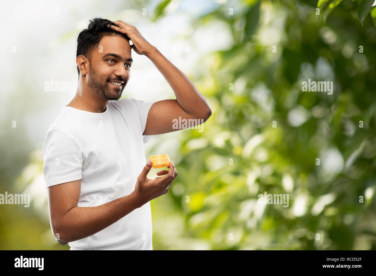 Indian uomo l'applicazione di cera per capelli o gel per lo styling Foto Stock