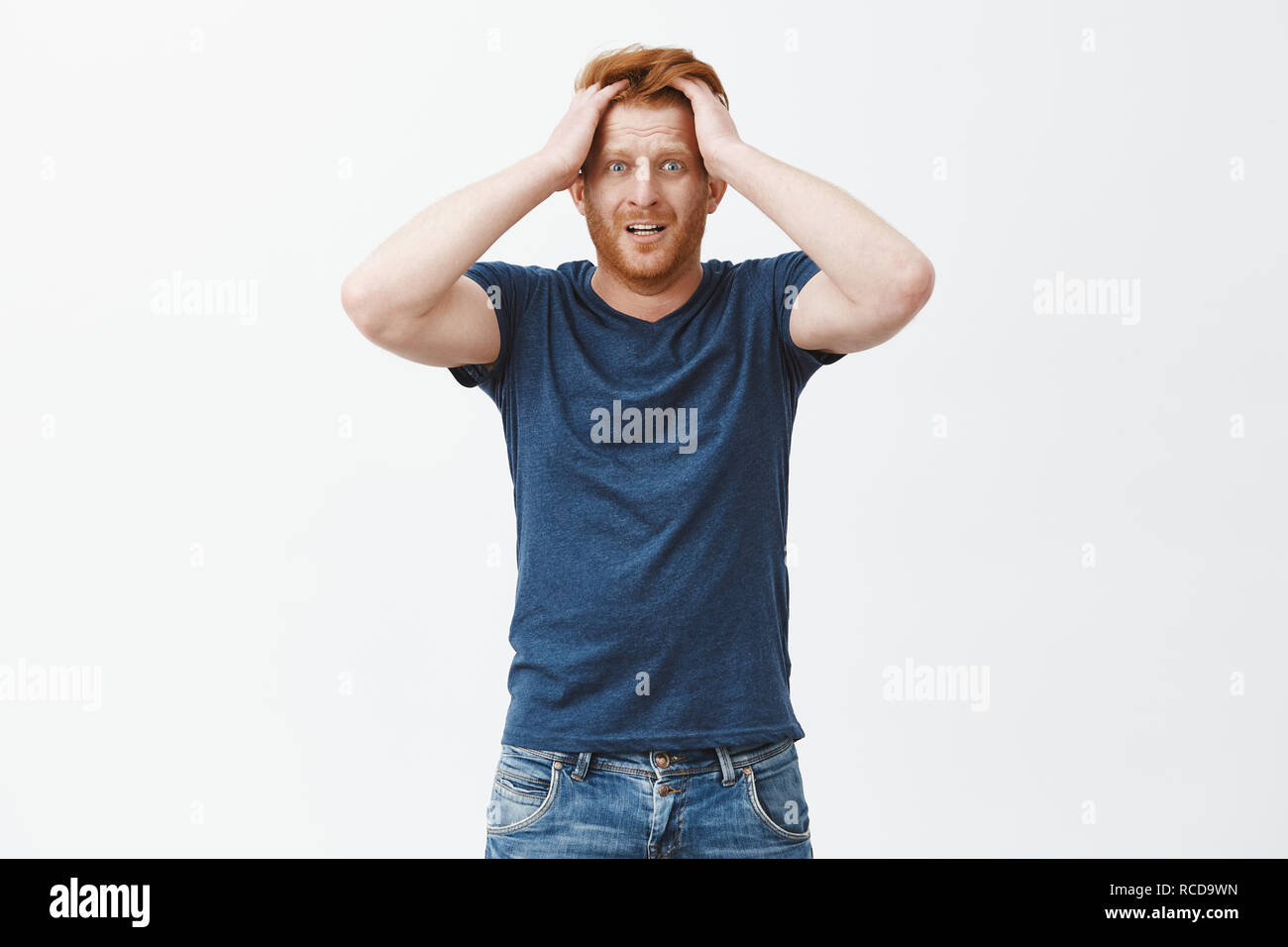 Guy inizia a farsi prendere dal panico per mancanza di tempo per preparare le carte. Nervosi e ansiosi di zenzero attraente uomo con barba, toccando i capelli, fissando scioccata e preoccupati per fotocamera, stucking in situazione problematica Foto Stock