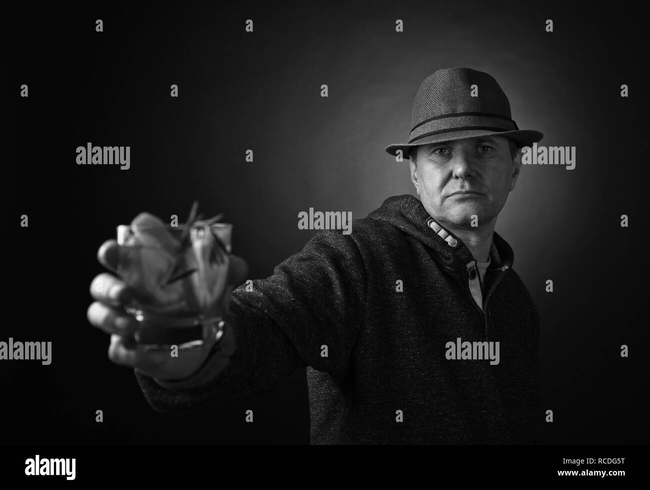 Uomo di mezza età in un cappello di bere un cocktail alcoolico con il limone. In bianco e nero. Foto Stock