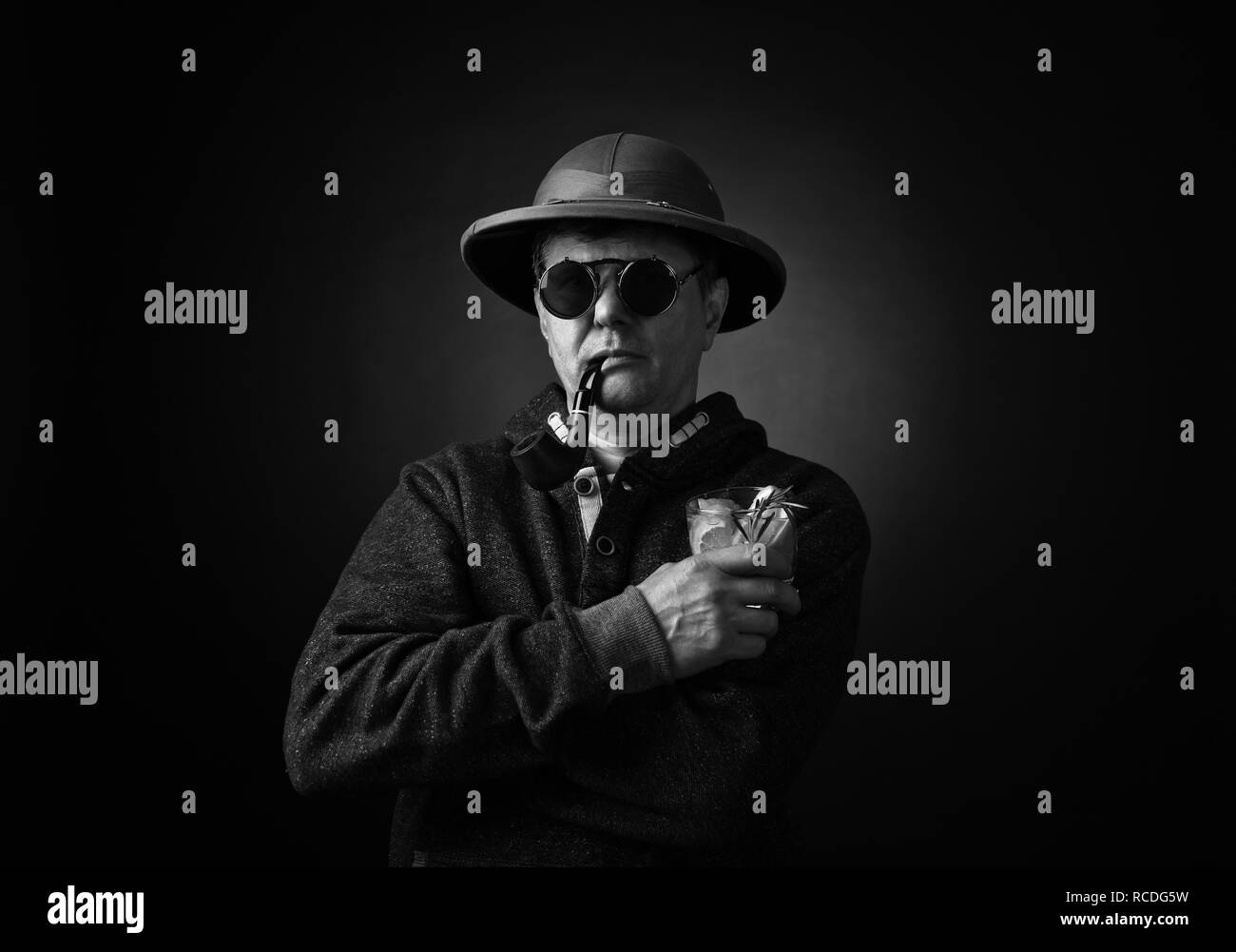 Uomo di mezza età in un cappello con il tubo e cocktail alcoolico. In bianco e nero. Foto Stock