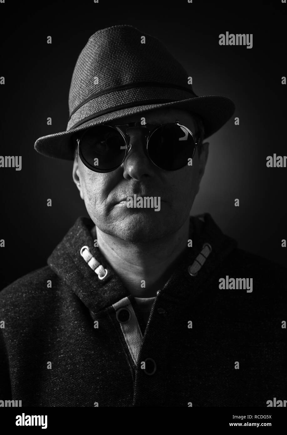 Uomo di mezza età in un cappello e occhiali da sole. In bianco e nero. Foto Stock