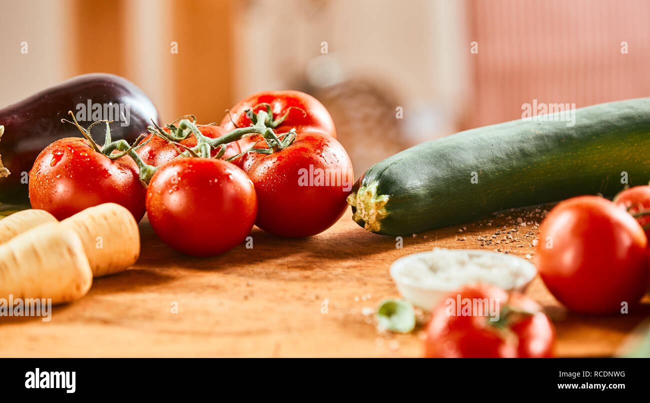 Un assortimento di verdure fresche su un bancone ligneo con zucchine, pomodori, rape e brinjal o impianto uovo in formato banner Foto Stock