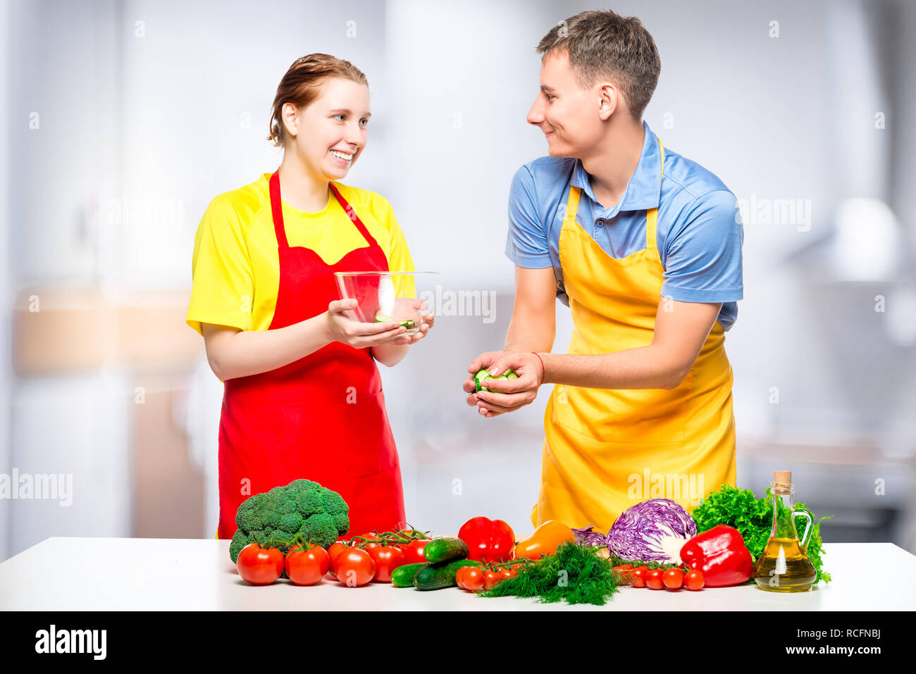 L uomo e la donna preparare una sana insalata di verdure in cucina Foto Stock