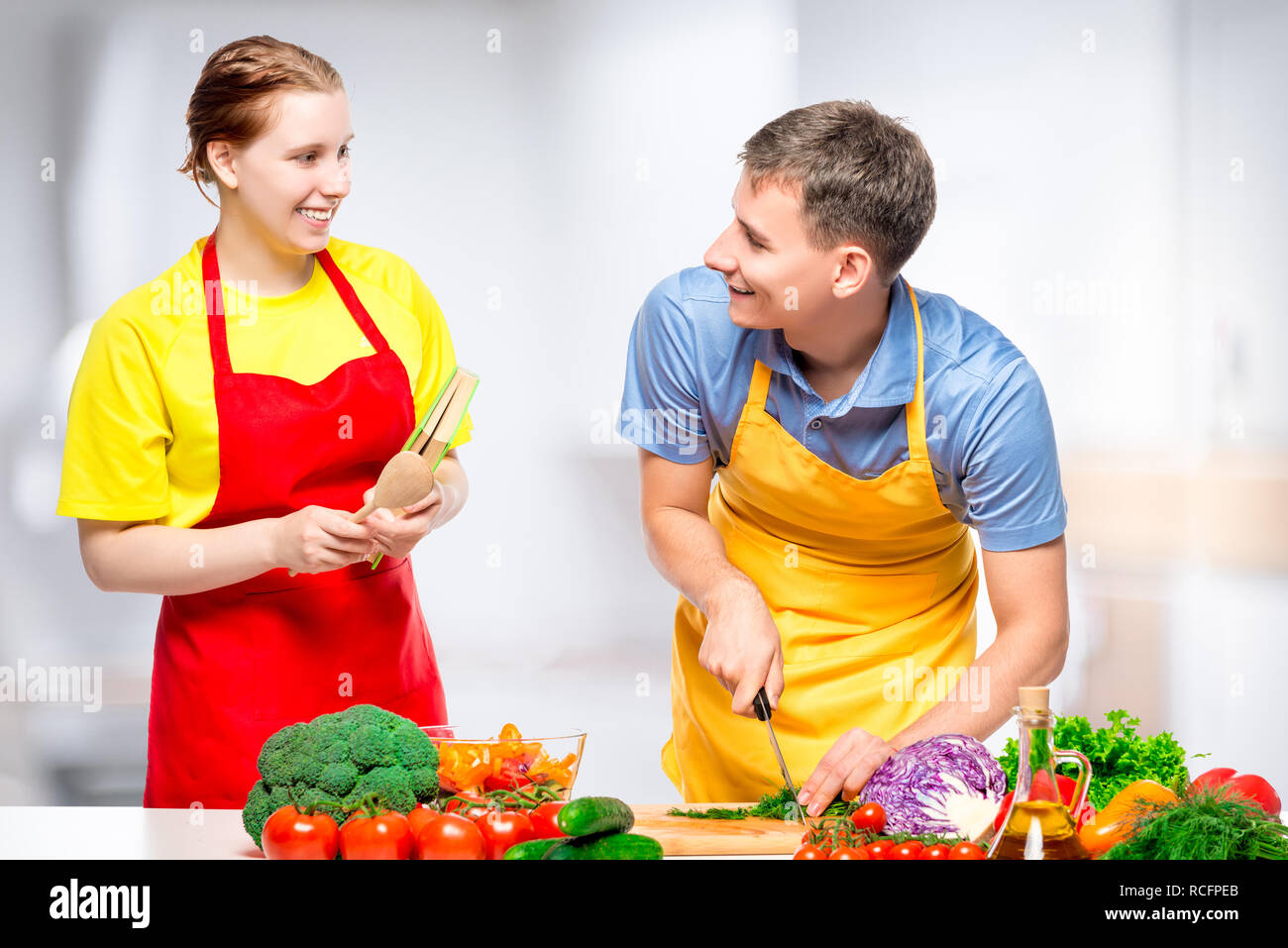 Coppia felice insieme di cucina sana e gustosa insalata di verdure in cucina Foto Stock