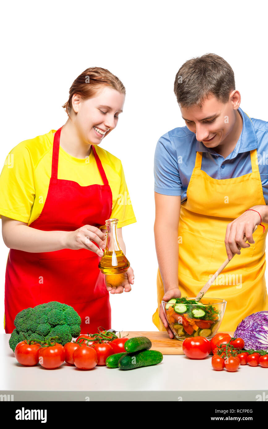 Ritratto di coppia felice mentre si cucina insalata di verdure su sfondo bianco Foto Stock