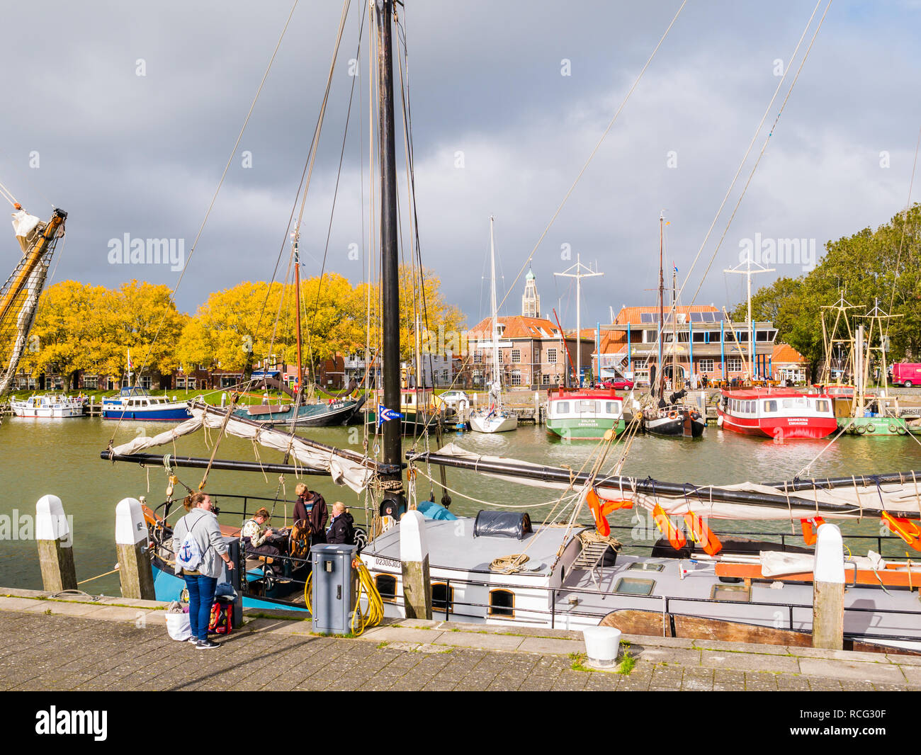 La gente e la tradizionale barca a vela nel porto esterno della città storica di Enkhuizen, Noord-Holland, Paesi Bassi Foto Stock