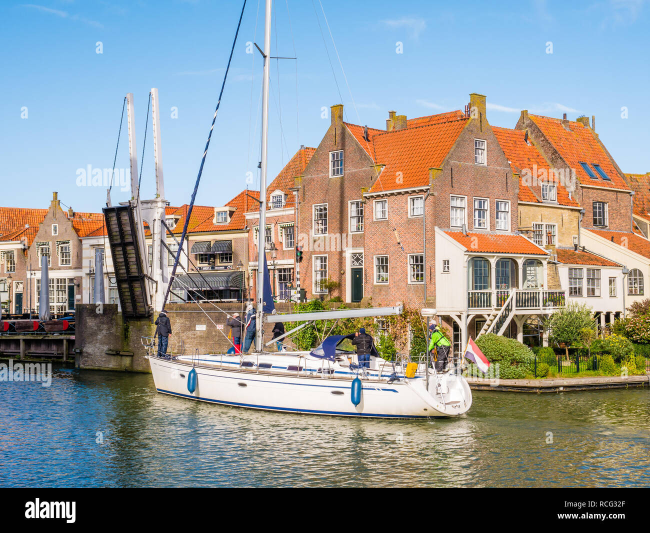 Le persone sulla barca a vela e di aprire il ponte levatoio al vecchio porto di Enkhuizen, Noord-Holland, Paesi Bassi Foto Stock