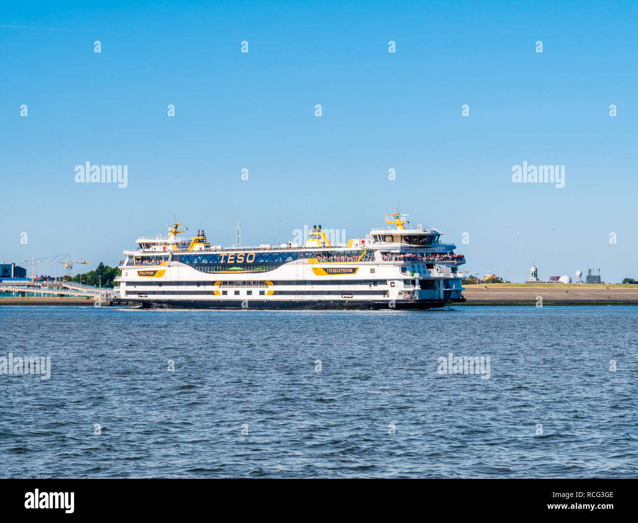 Ferry boat con le persone al di fuori sul ponte partenza dal porto di Den Helder per il texel attraversando Marsdiep stretto di mare di Wadden, Noord-Holland, Paesi Bassi Foto Stock