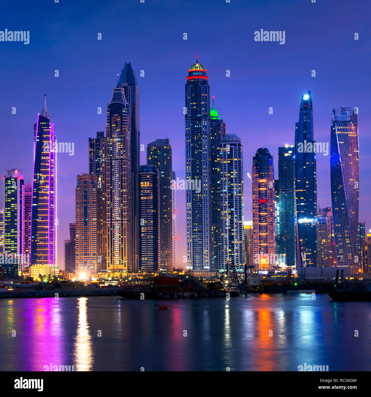 Marina di Dubai skyline notturno con acqua riflessioni, Emirati Arabi Uniti Foto Stock