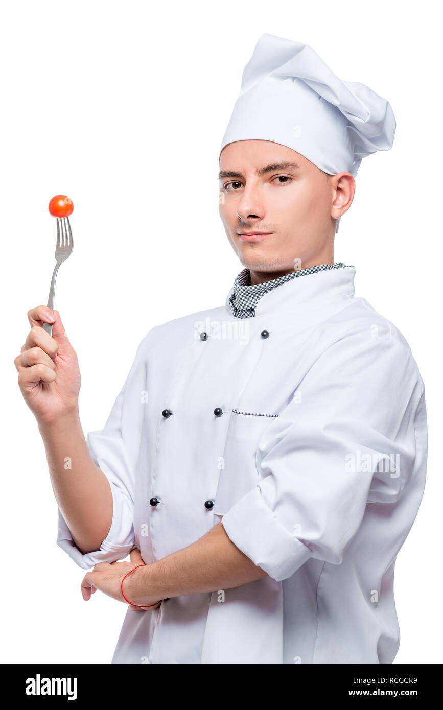Ritratto di un successo professionale cook con un pomodoro ciliegino su una forcella, girato su sfondo bianco in studio Foto Stock