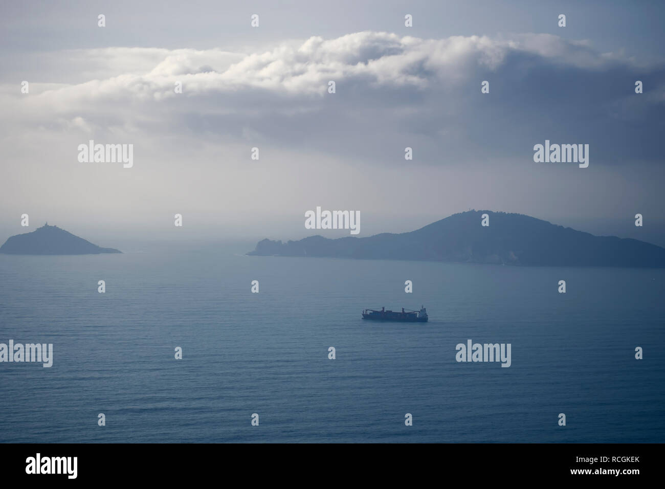 Misty evening con nave cargo, guardando oltre il golfo dei Poeti, provincia della Spezia, Italia. L'Isola Palmaria visibile. Foto Stock