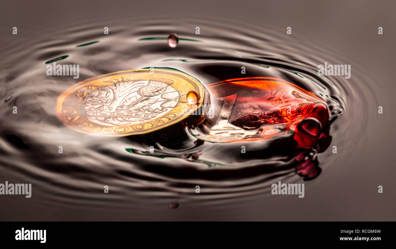 Colore rosso goccia d'acqua schizzi su un Euro e stagno inglese sterling brexit coin Foto Stock