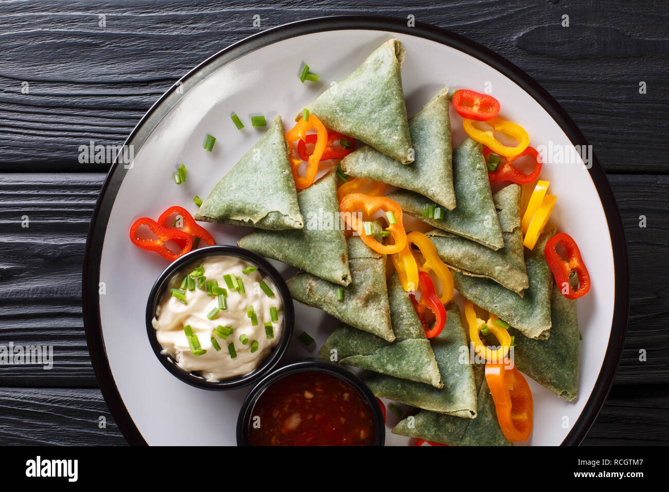 Gli spinaci vegetariana samosa con salse close-up su una piastra sul tavolo. Parte superiore orizzontale vista da sopra Foto Stock