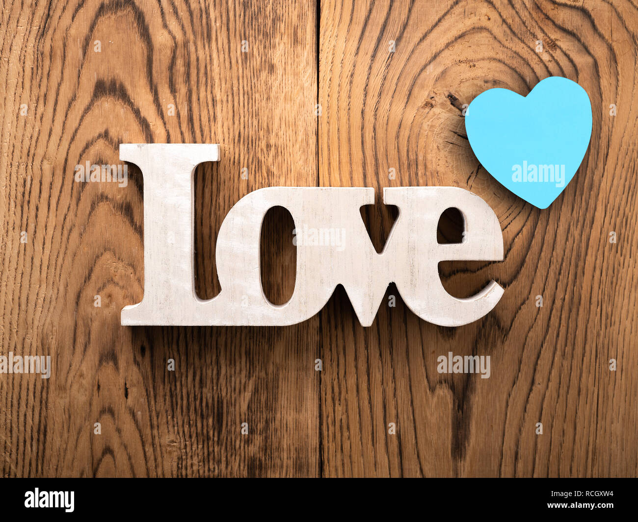 La parola 'amore' e cuori su sfondo di legno Foto Stock