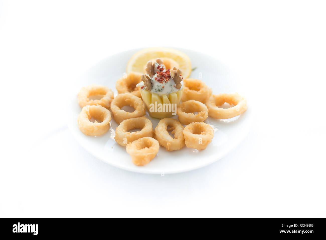 Frittura di anelli di totano impanati o polpo (calamari) con salsa isolati su sfondo bianco. Frittura di anelli di totano cibo. Calamari fritti anelli su backgro isolato Foto Stock