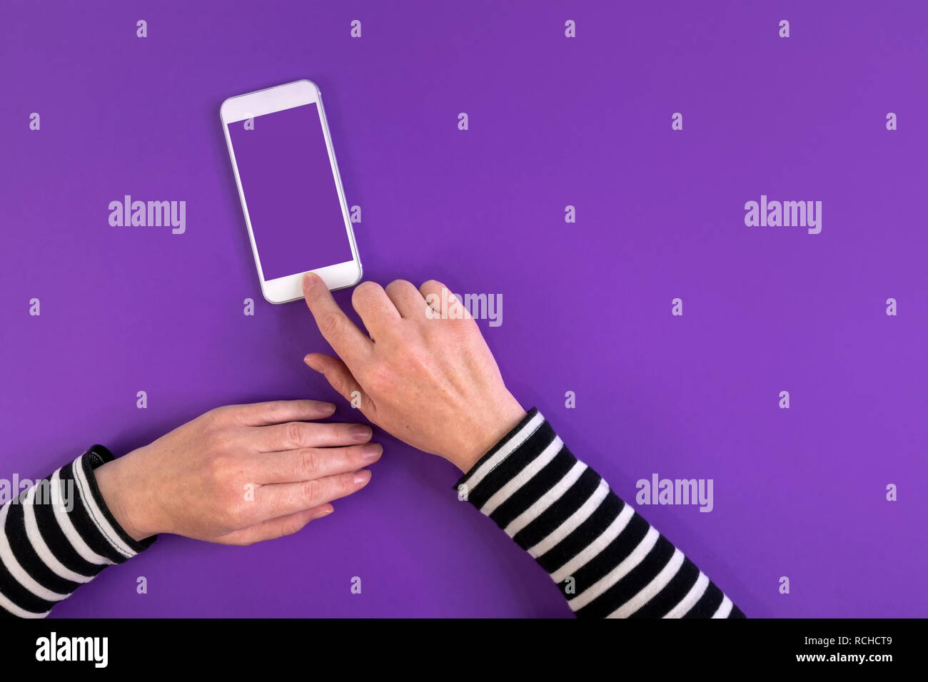 Smartphone nelle mani femminili mock up top view copia spazio su sfondo a raggi ultravioletti Foto Stock