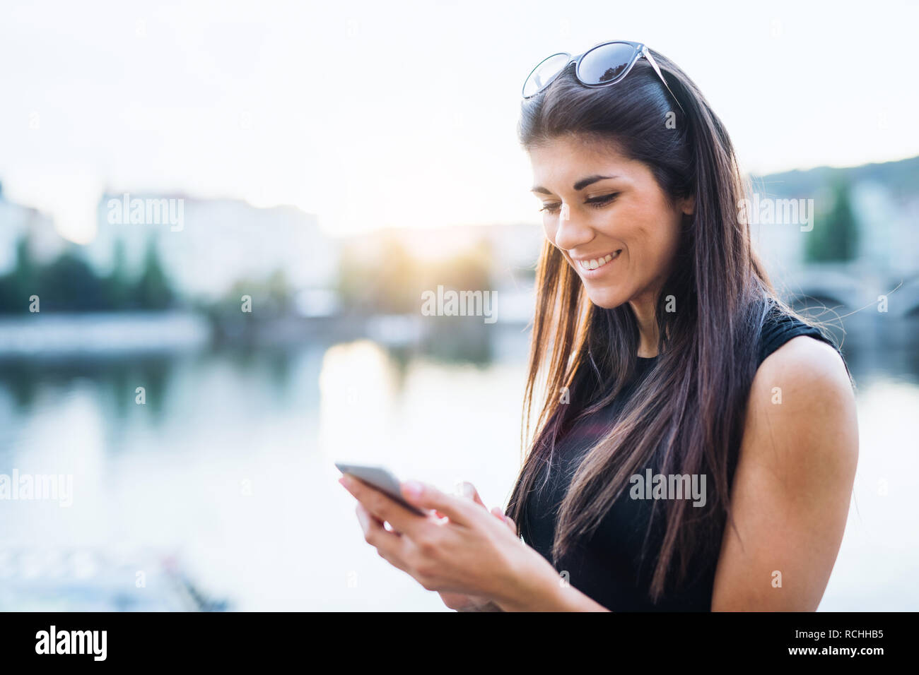Bella donna in abito nero in piedi da un fiume nella città di Praga, la messaggistica di testo. Foto Stock