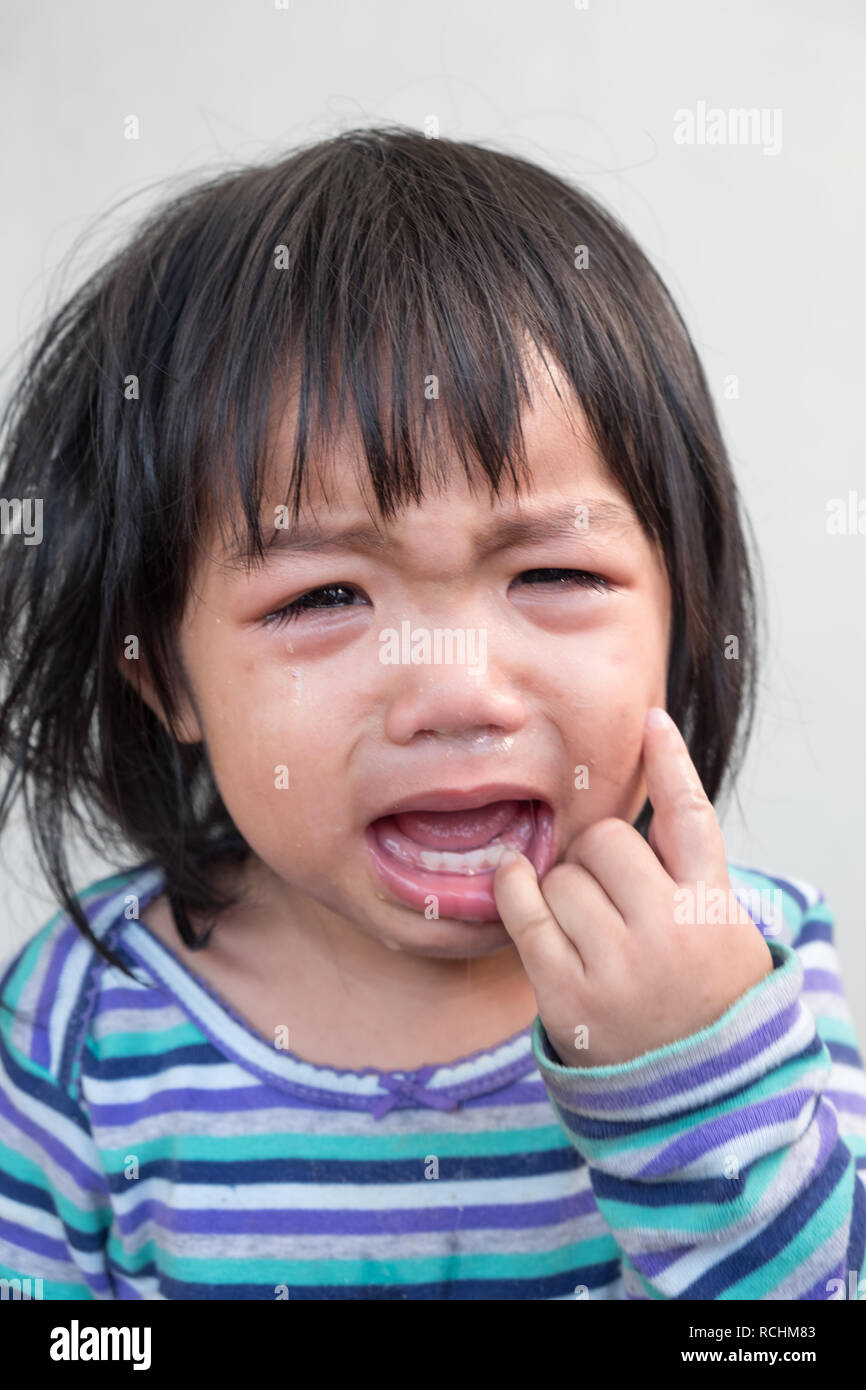 Scena emotiva. Ritratto di bimbo che piange ragazza asiatica. Foto Stock