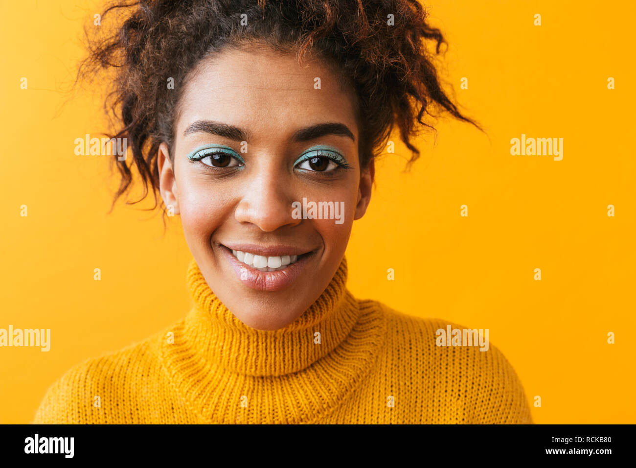 Ritratto di attraente americano africano donna con acconciatura afro sorridente in telecamera isolate su sfondo giallo Foto Stock
