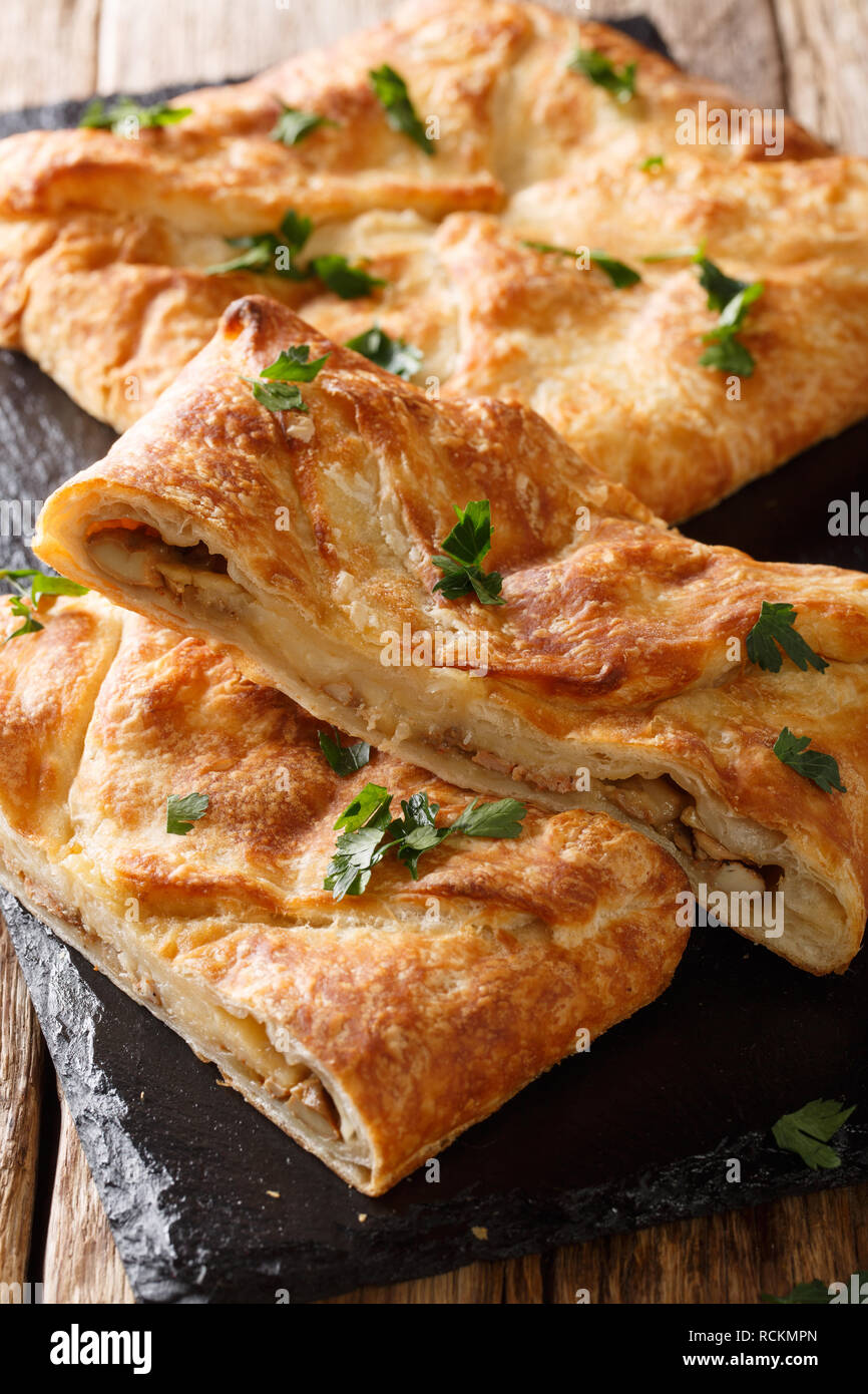 Khachapuri flatbread un tradizionale piatto di stile georgiano con formaggio suluguni, uova closeup sul piano verticale. Foto Stock