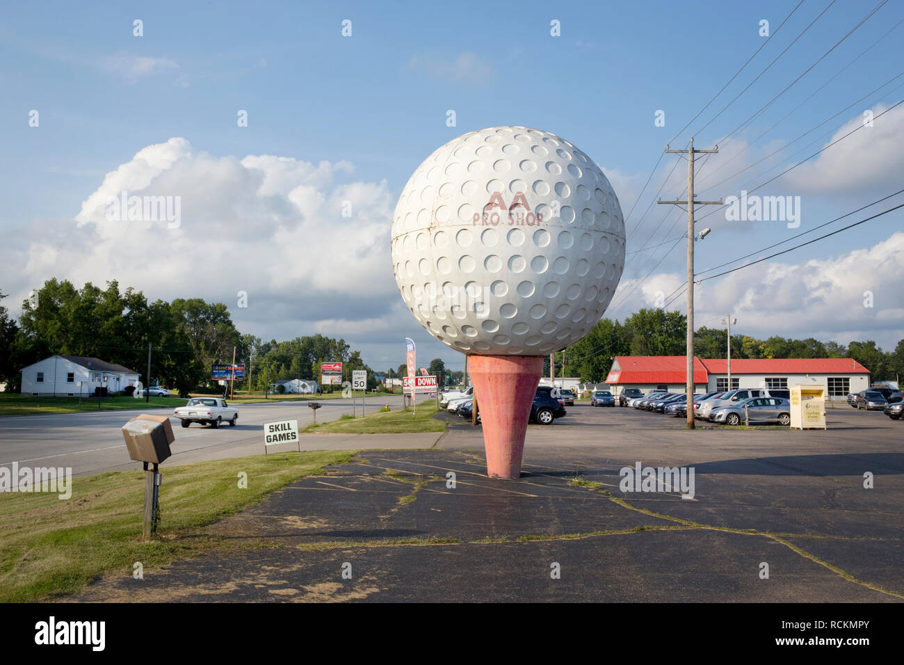 Una gigantesca palla da golf e tee pubblicità in un parcheggio. Foto Stock