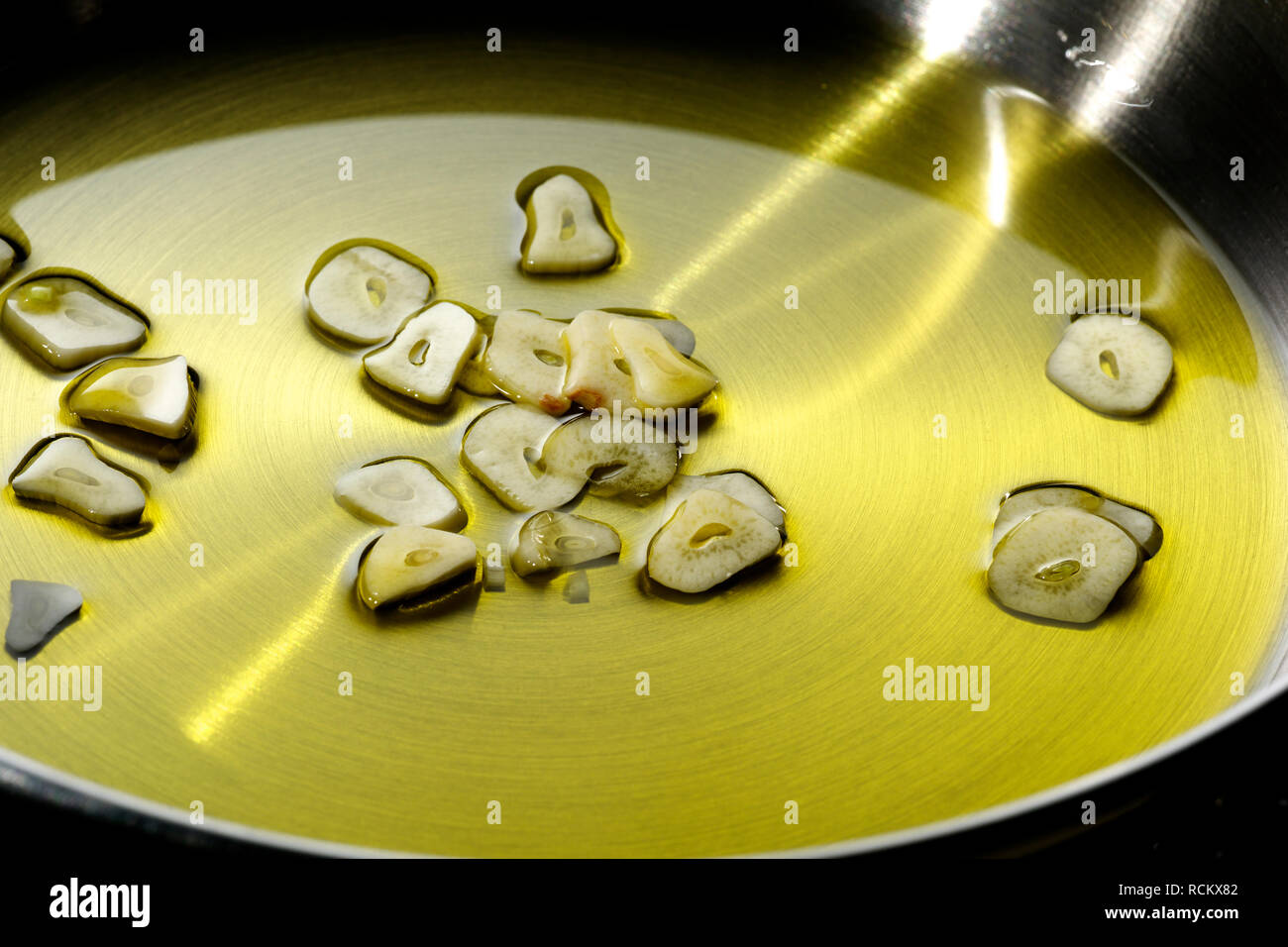Tagliate a fettine sottili di aglio e olio da cucina in padella, ad alto angolo di visione, close up Foto Stock