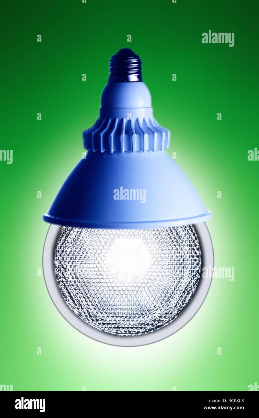 Moderna e luminosa lampadina con raccordo blu, vicino, sfondo verde Foto Stock