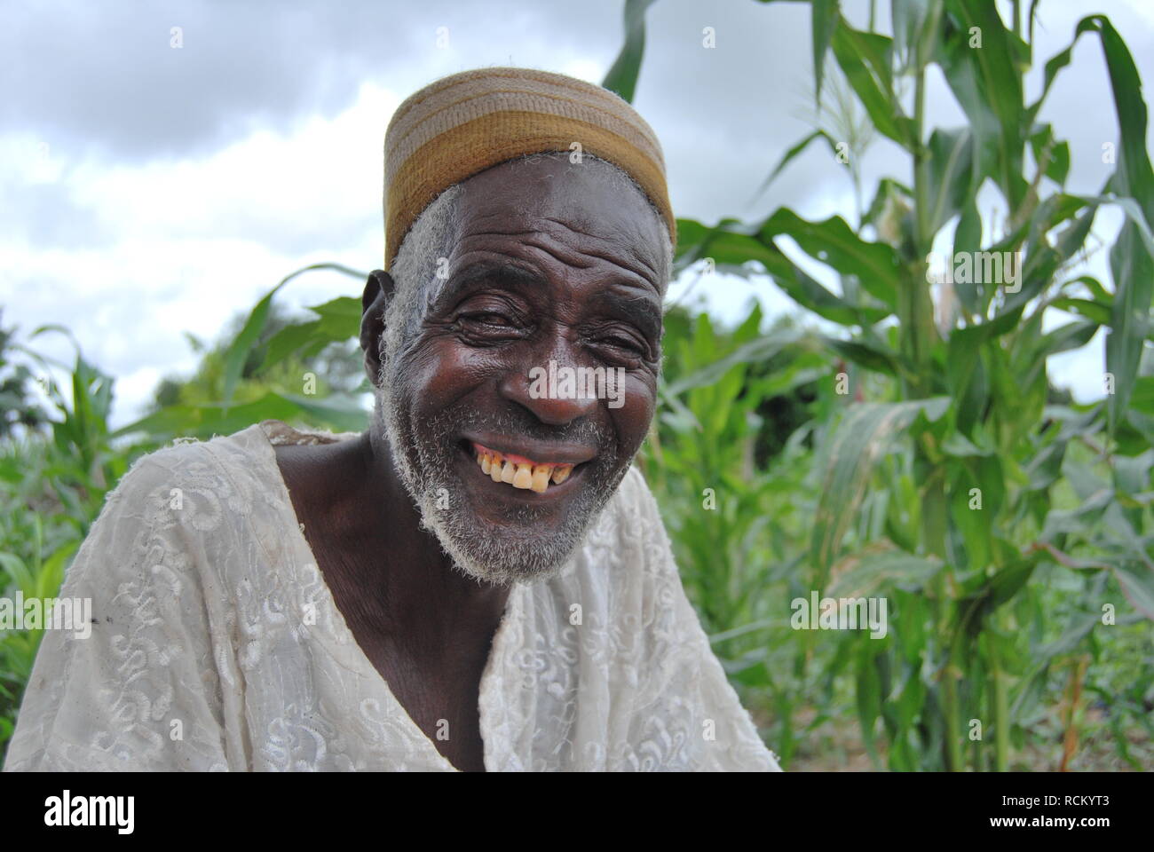 Un vecchio uomo Fulani in corrispondenza del bordo di un campo di grano in Niger, Africa Foto Stock