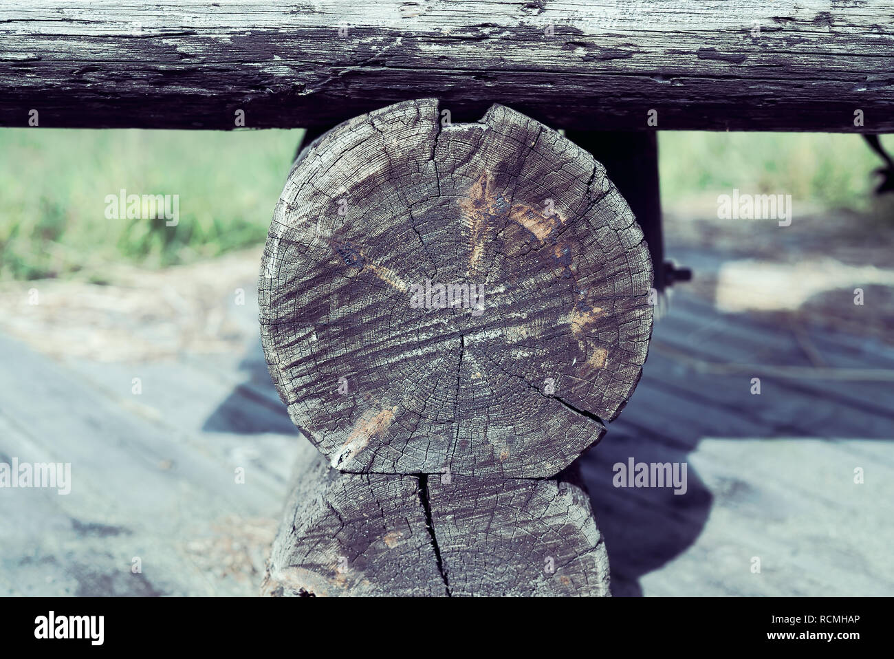 Primo piano dettaglio dell'artigianato di una grossolana weathered e screpolata panca in legno realizzate in legno naturale, registri con copyspace Foto Stock
