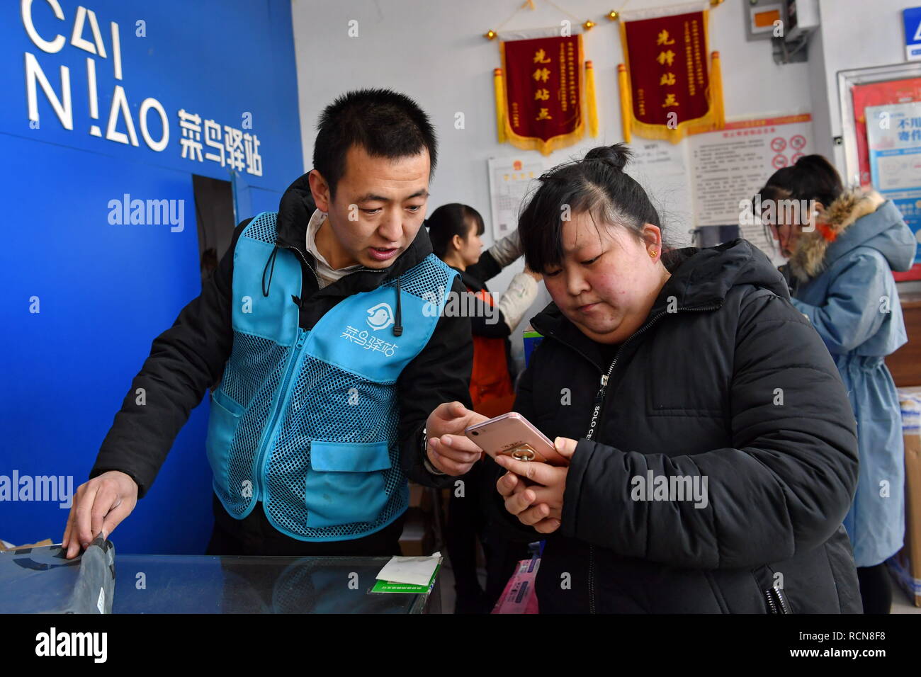 Taiyuan cinese nella provincia di Shanxi. 15 gennaio, 2019. Zhang Xin (L), la testa di un Cainiao locale stazione di rete, controlla un cliente di esprimere il numero di tracking in Taiyuan, nel nord della Cina di nella provincia di Shanxi, Gennaio 15, 2019. Come il Festival di Primavera di approcci e di società e-commerce " shopping on line promozioni kick off, Zhang Xin e i suoi colleghi hanno per gestire 3,000-5.000 pacchi ogni giorno. Nonostante il carico di lavoro pesante, Zhang Xin tenta di offrire il servizio migliore per comodità del cliente. Credito: Cao Yang/Xinhua/Alamy Live News Foto Stock