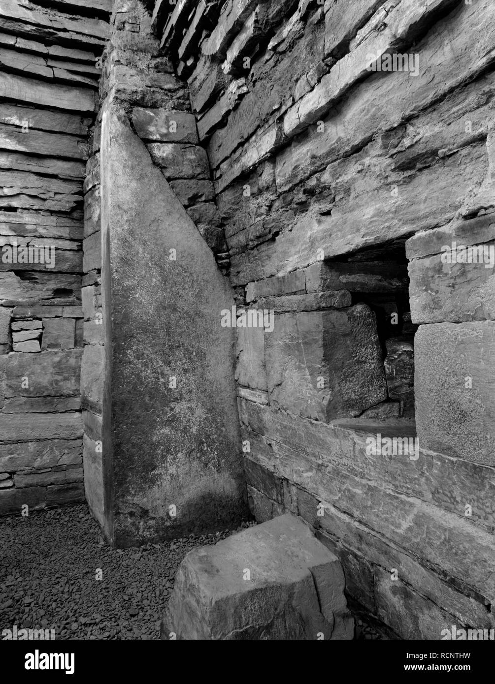 Vista interna di Maes Howe Neolitico chambered cairn mostra NW corner contrafforte della camera principale con ingresso al lato N cellula & il suo blocco di pietra. Foto Stock