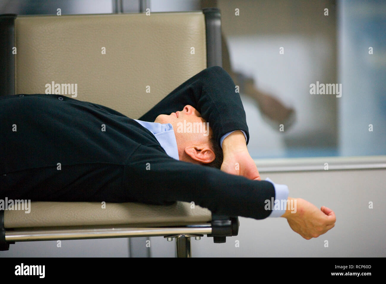 Metà di uomo adulto di dormire su una sedia. Foto Stock