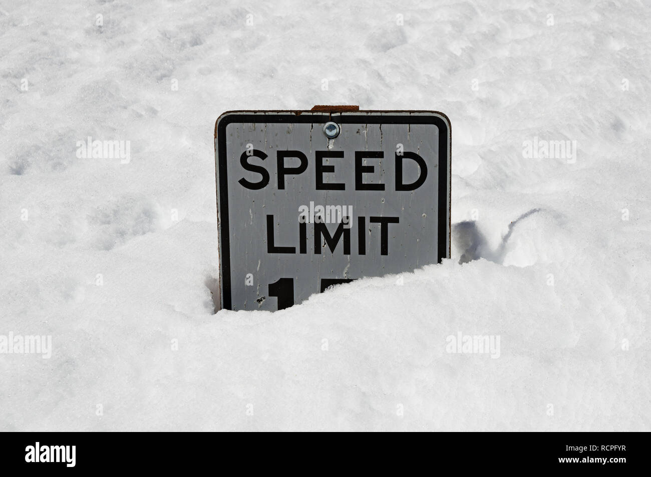 Il vecchio limite di velocità 15 segno mezzo sepolto nel profondo neve invernale Foto Stock