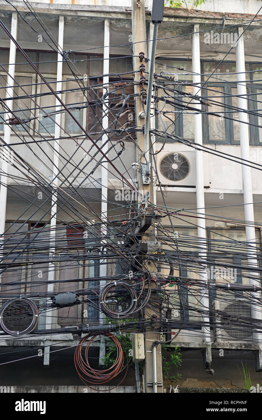 Un groviglio di elettrico e di cablaggio di comunicazione a Bangkok in Tailandia Foto Stock